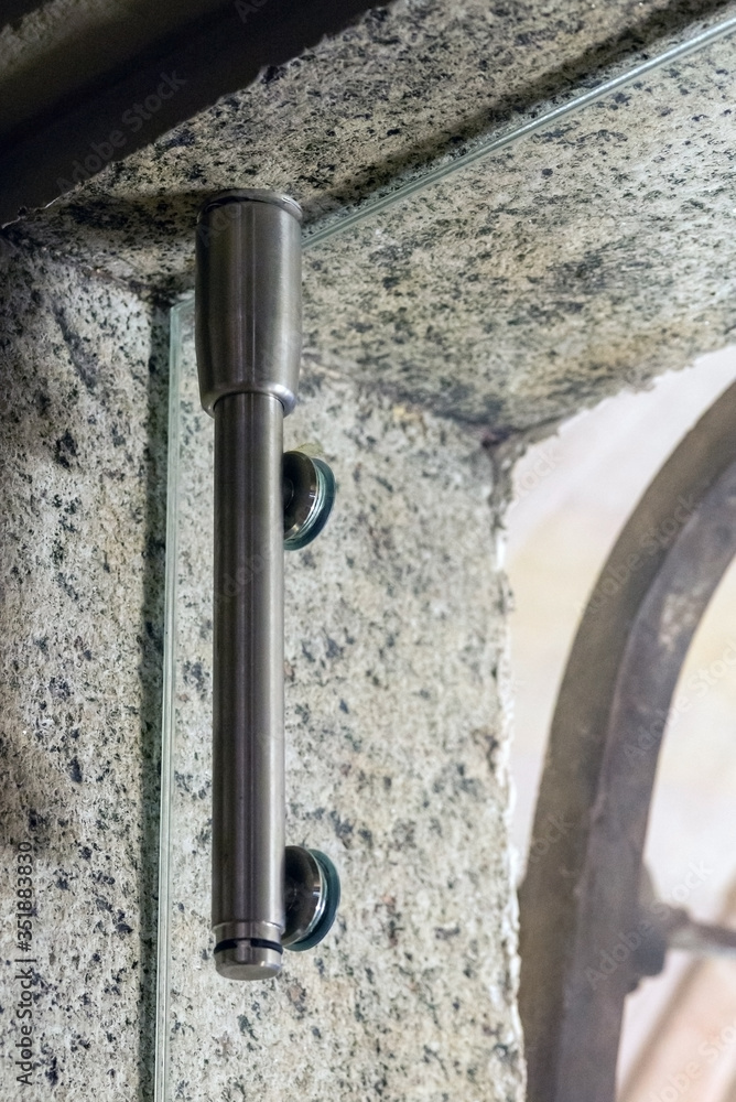 Glass door hinges metal fittings with door locking mechanism, close up Glass door hinges metal fittings with door locking mechanism, close up