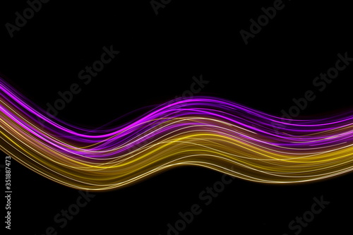Long exposure photograph of neon pink and gold colour in an abstract swirl, parallel lines pattern against a black background. Light painting photography.