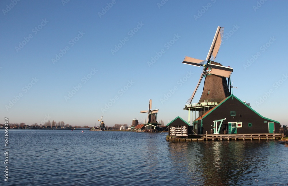 Zaanse Schans, The Netherlands - 12/30/2019: A lake beside some Windmills in December 30, 2019 on Zaanse Schans. Zaanse Schans is a neighborhood in the Dutch town of Zaandam, near Amsterdam.
