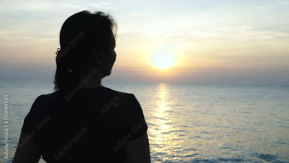 Silhouette of woman that admires the beautiful sea view during sunrise. Silhouette of woman that admires the beautiful sea view during sunrise.