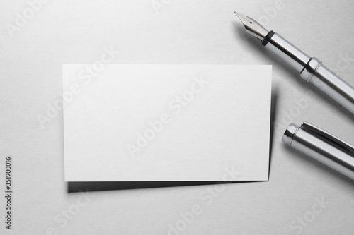 Mockup of business card with fountain pen at white paper background