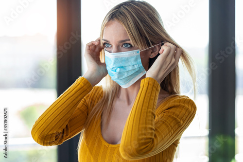 Young woman wearing an hygienic mask to prevent others from a virus in the office. photo