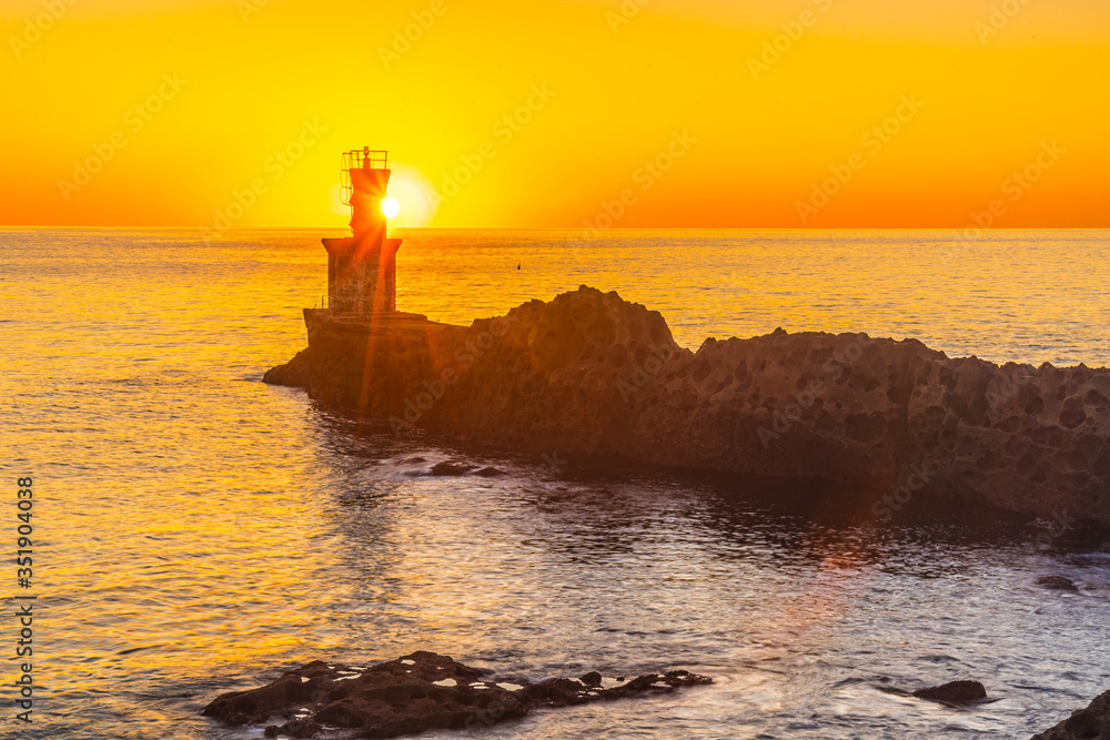 Detail of the sun behind the lighthouse at sunset in the town of Pasajes San Juan. Gipuzkoa, Basque Country