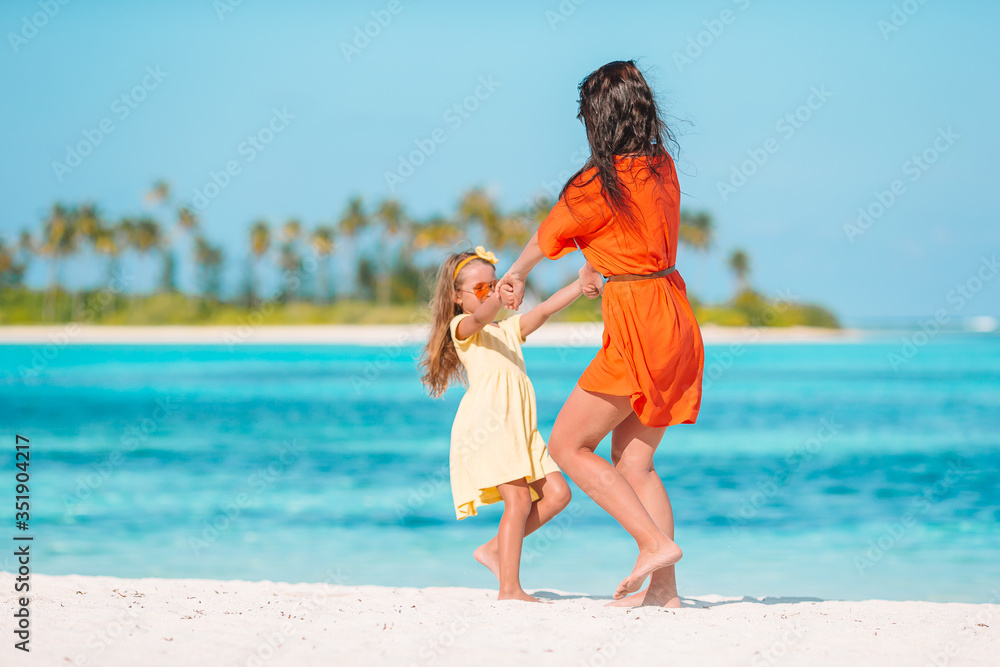 Beautiful mother and daughter at Caribbean beach enjoying summer vacation.