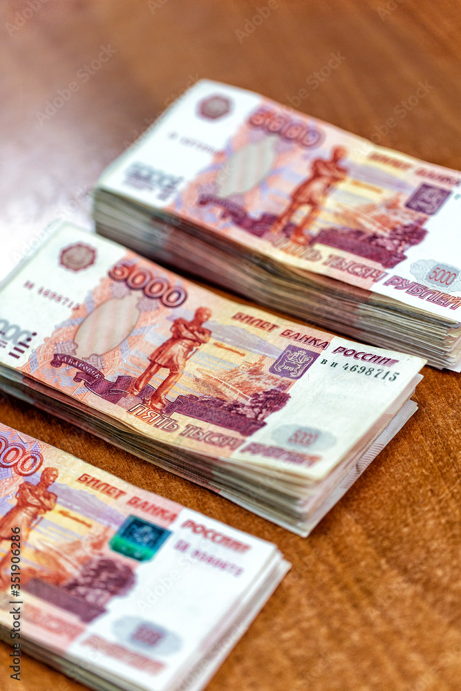 Piles of paper money five thousand rubles on table closeup Piles of paper money five thousand rubles on table closeup