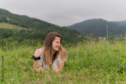una chica guapa tumbada en un prado verde