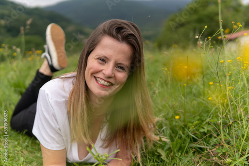 una chica guapa tumbada en un prado verde