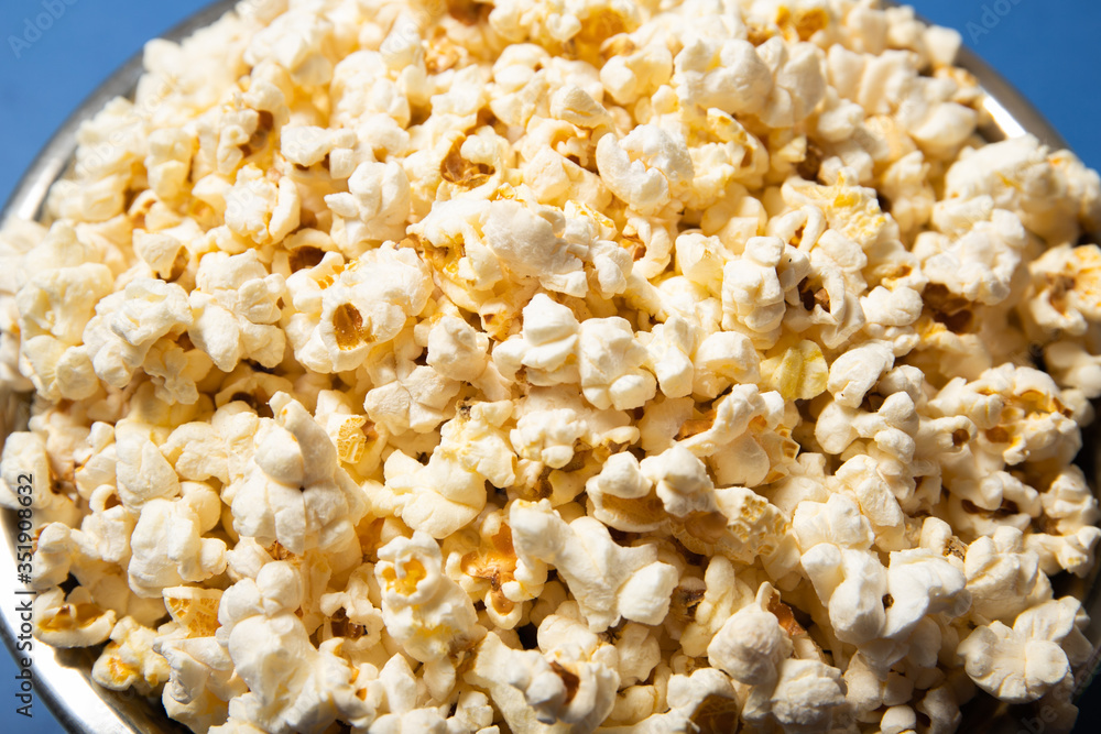 Popcorn in a plate close-up. Blue background