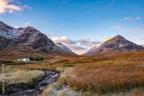 Cottage overlooked by Etive Mor, Glencoe in the dramatic highlands of scenic Scotland, fantastic adventure travel destination or holiday vacation to view picturesque scenery at sunrise or sunset © Andy