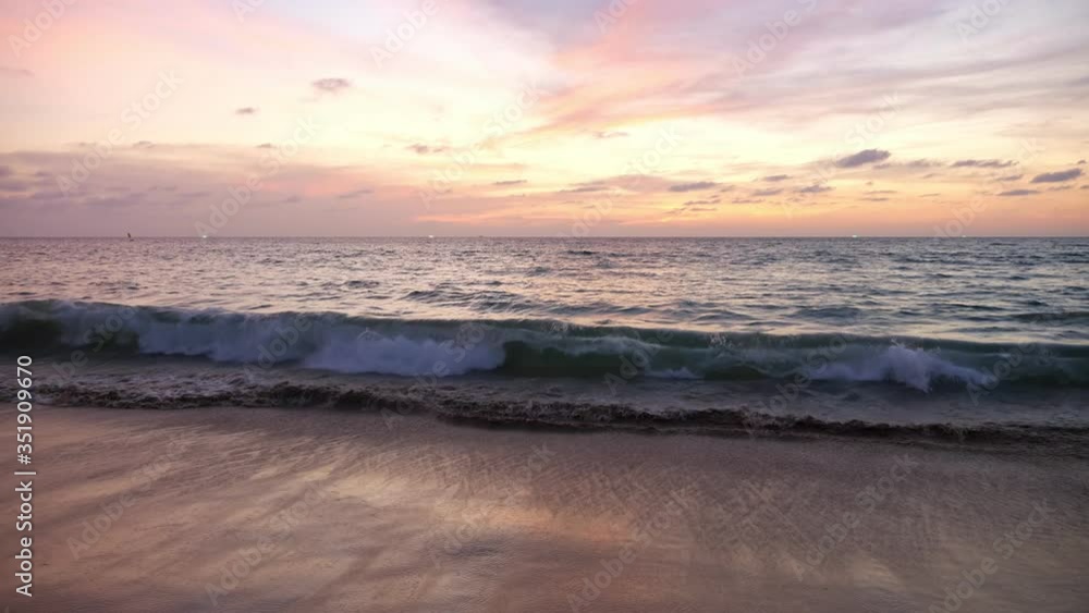 ocean calm waves roll on empty sandy beach under beautiful pink sky with clouds at sunset time slow motion ocean calm waves roll on empty sandy beach under beautiful pink sky with clouds at sunset time slow motion