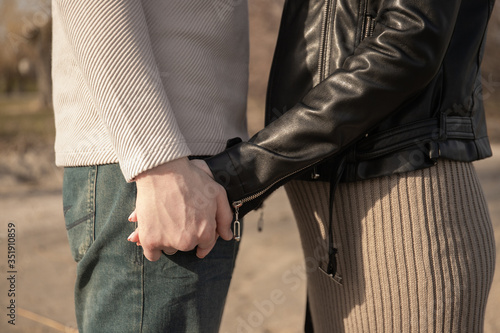 The guy and the girl are holding hands in the park. Couple in love. Pregnancy