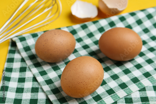 Chicken eggs on checkered kitchen towel, closeup