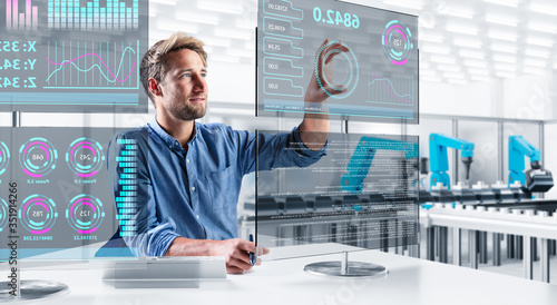 Ingenieur steuert eine moderne Produktionsanlage über verschiedene Touchscreens