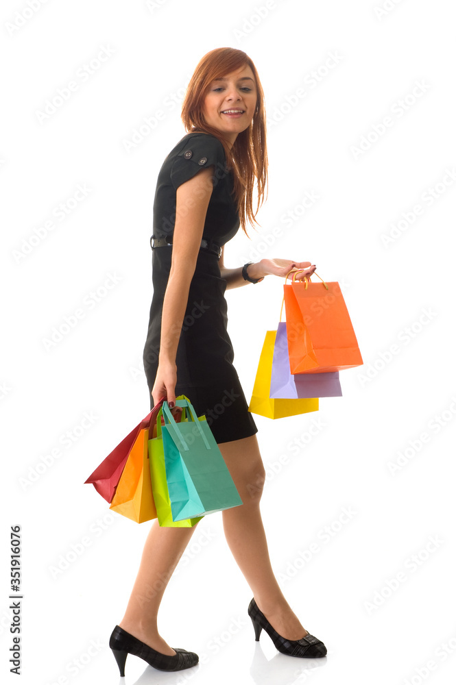 An excited young woman holding her colourful shopping bags up

