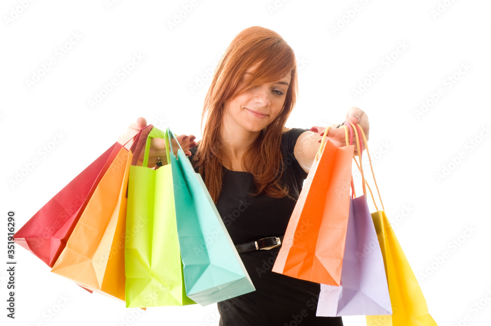 An excited young woman holding her colourful shopping bags up

