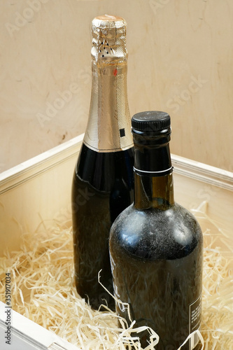 bottles of expensive elite wine and champgne  in a wooden box with shavings, wine tasting, online order and delivery wine in coronavirus time, internet wine shops concept. Vertical view photo