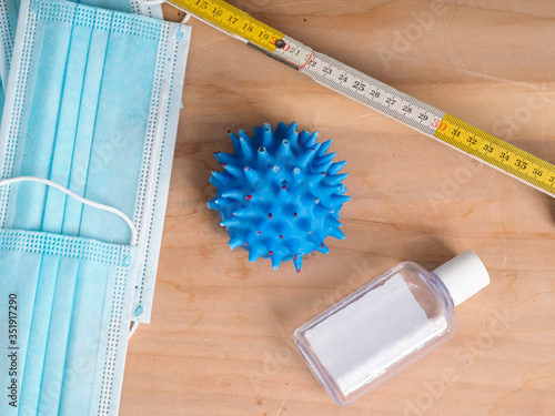 lat llay of coronavirus icons as facial mask , folding meter  , ices cubes and others on background representing social distancing concept next summer in educational clear way photo