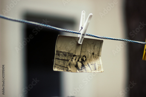 The photo is hanging on a rope fixed with a clothespin