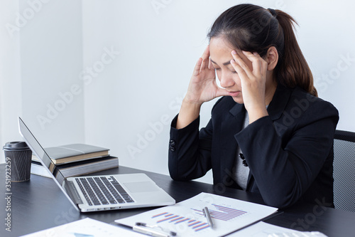 She is stressed due to the economic downturn causing migraine headaches, Financial accountants work on the analysis and summary of company revenue in real estate, Hard work and overtime work concept.