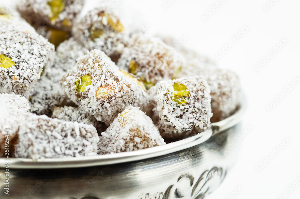 Turkish delight in hollowware isolated on white background, traditional turkish sweet double roasted with pistachio nuts and coconut Turkish delight in hollowware isolated on white background, traditional turkish sweet double roasted with pistachio nuts and coconut
