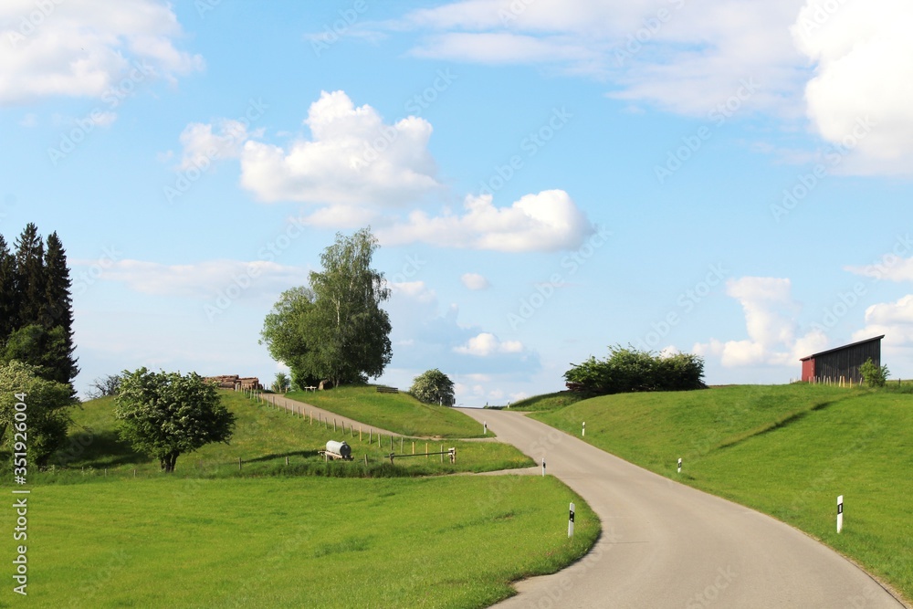 Kurvige Straße auf einen Hügel hinauf, Landschaft im Allgäu, Bayern Kurvige Straße auf einen Hügel hinauf, Landschaft im Allgäu, Bayern