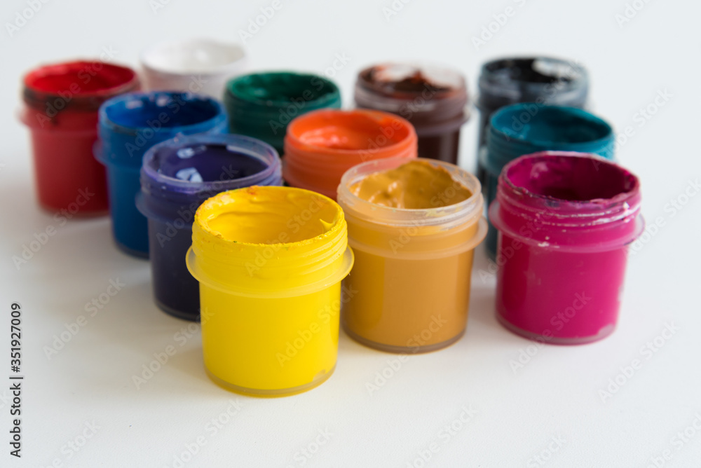 Open cans of paint, top view. Variety, many colors of gouache. Background, texture. Open cans of paint, top view. Variety, many colors of gouache. Background, texture.