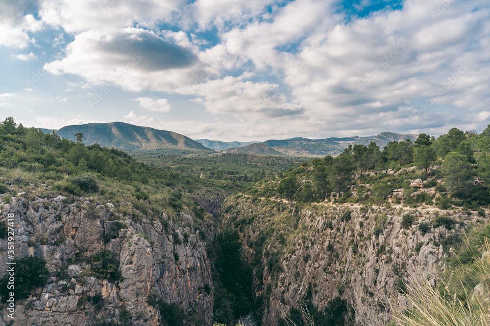 Scenic view of a canyon. Spanish hills and   dramatic clouds. Mediterranean green and arid  landscape.
