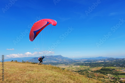 Professional man paragliding in blue sky in a sunny day