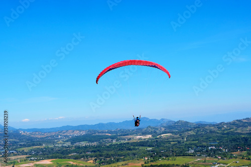 Professional man paragliding in blue sky in a sunny day