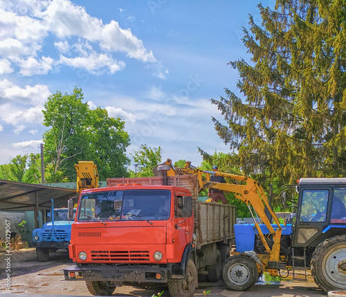 Wheel tractor loading a truck lorry after felling trees