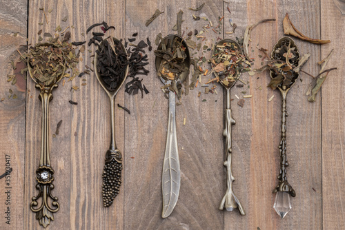 Dried black and green tea leaves on vintage spoons