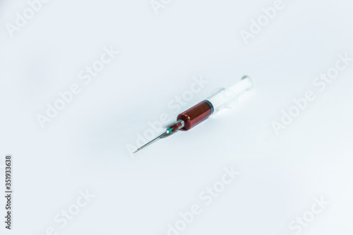 Syringe with blood on white background.
