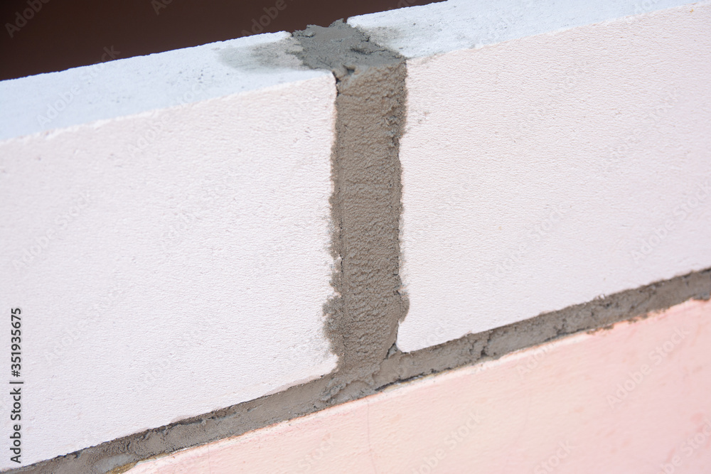Bricklayer worker installing Lightweight Concrete on exterior wall with trowel putty knife. Bricklayer worker installing Lightweight Concrete on exterior wall with trowel putty knife.