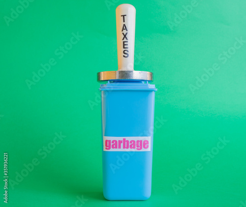 Wallpaper Mural a mallet with the word taxes compresses crushes a garbage can /a mallet with the word taxes compresses crushes a garbage can represents the tax burden on garbage Torontodigital.ca