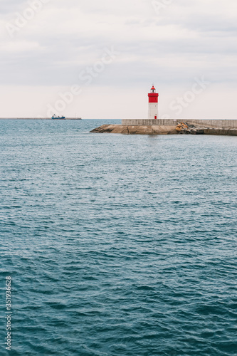 Red and white lighthouse on the horizon © La Objetiva
