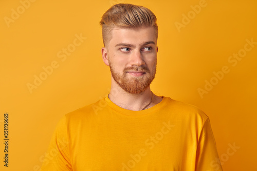Portrait of handsome young caucasian man with beard on yellow backgroun © antianti
