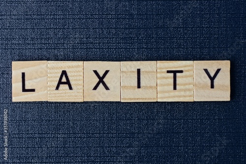 фотографія text on word laxity from gray wooden letters on a black table