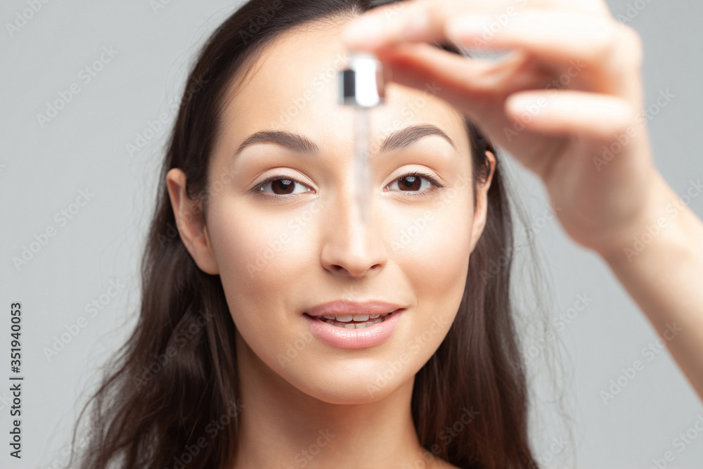 Young beautiful woman with pipette with clean perfect skin closeup Young beautiful woman with pipette with clean perfect skin closeup