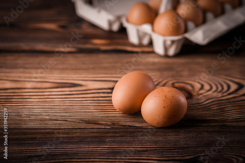 Detail close-up of chicken eggs on the old brown wooden background.