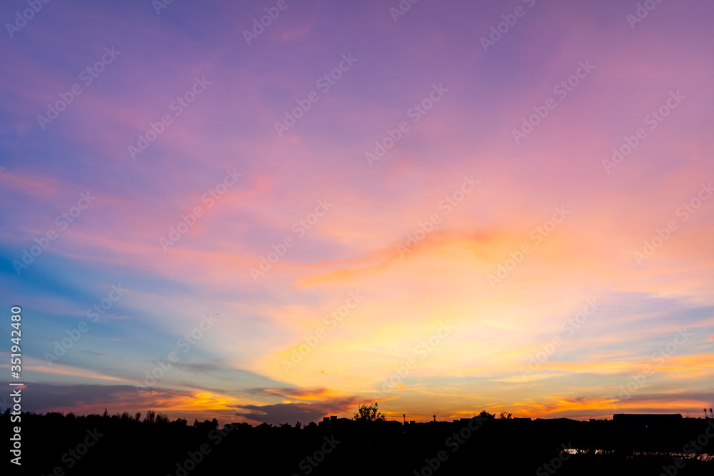Photographs of the sky after the sunset, with colorful and shaded grasslands in the community crossing the horizon.