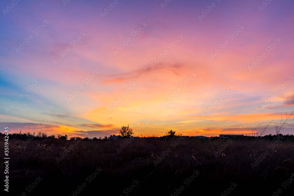 Photographs of the sky after the sunset, with colorful and shaded grasslands in the community crossing the horizon.