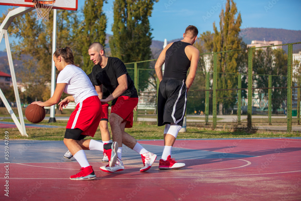 Obraz premium Group Of Young Friends Playing Basketball Match