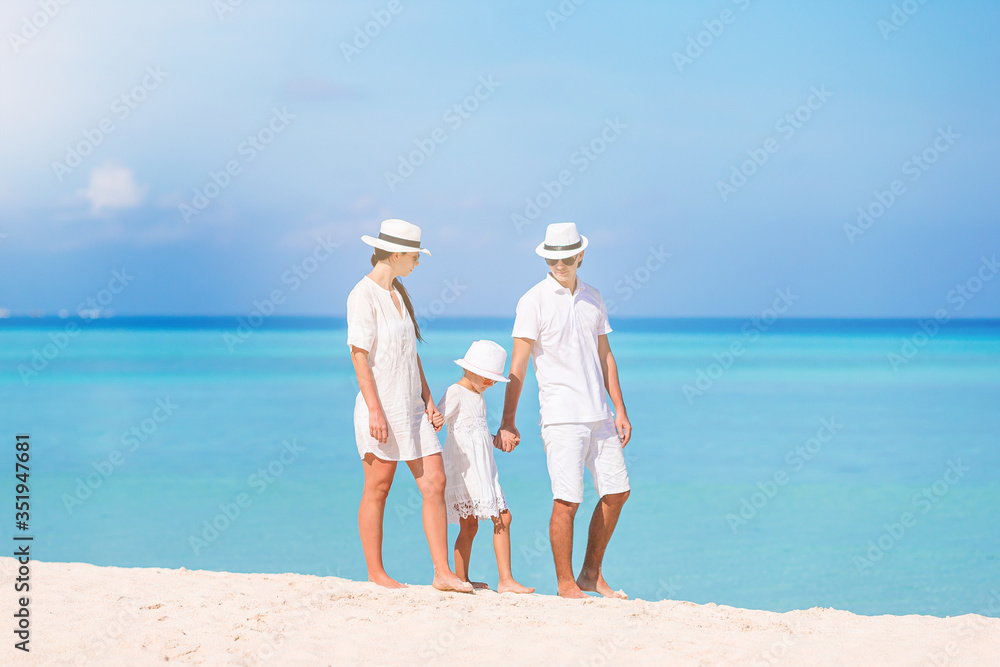 Happy family of three having fun together on the beach Happy family of three having fun together on the beach