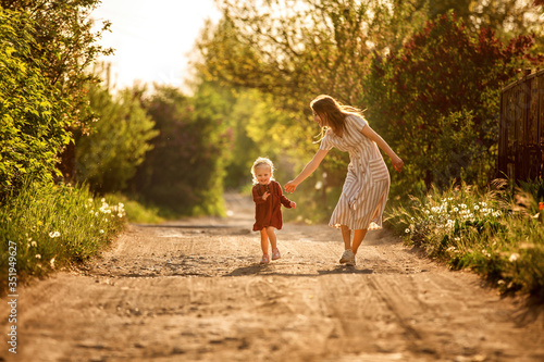 girl and mother run along the track at sunset, indulge, have fun, relationship