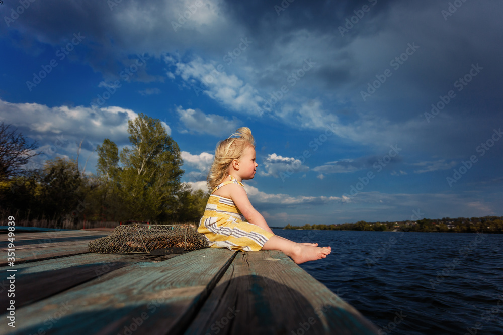 girl sitting on the bridge and fishing
