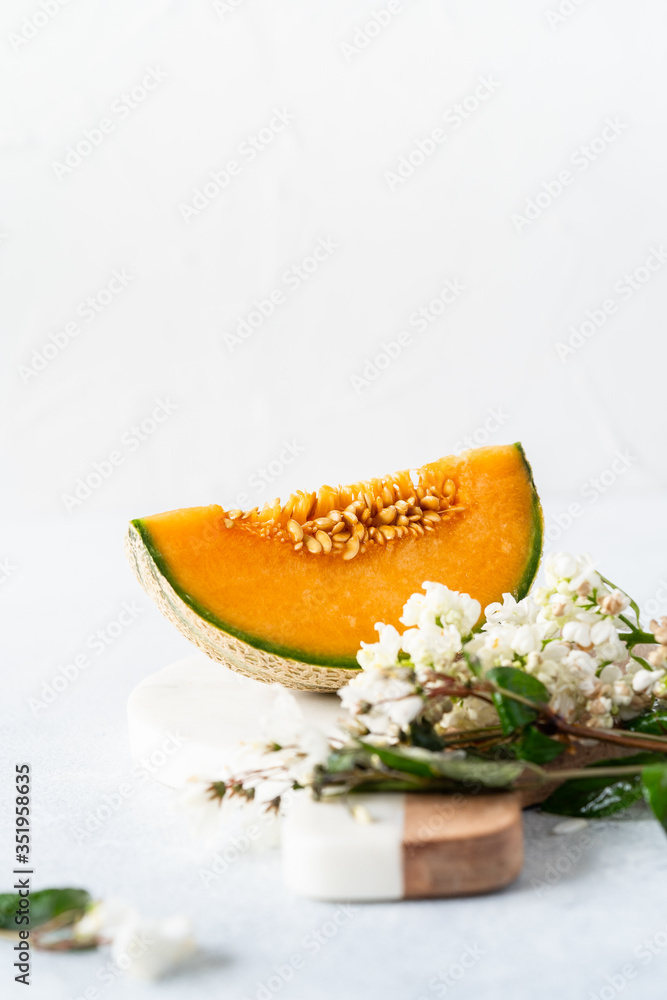 Fresh Cavaillon melon with white flowers on a white background. Fresh Cavaillon melon with white flowers on a white background.