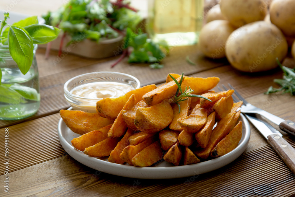 Roasted potato chips with sauce and herbs. Wooden background, copy space. Roasted potato chips with sauce and herbs. Wooden background, copy space.