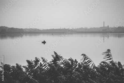 Beautiful landscape fisherman on a boat in a beautiful lake