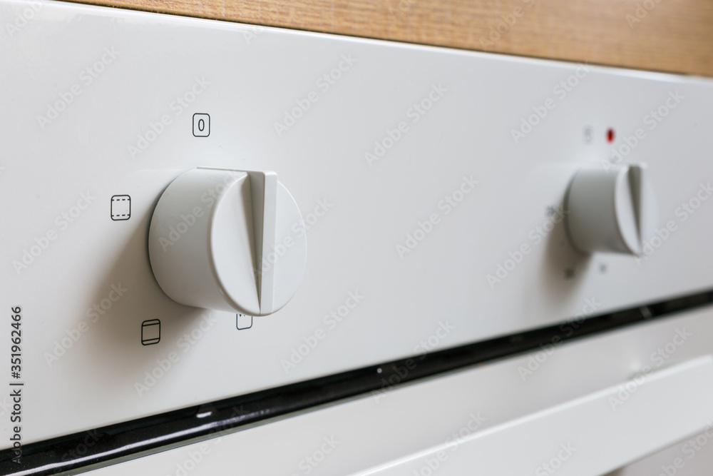 White electric oven switches. Control knobs for modern kitchen appliances White electric oven switches. Control knobs for modern kitchen appliances