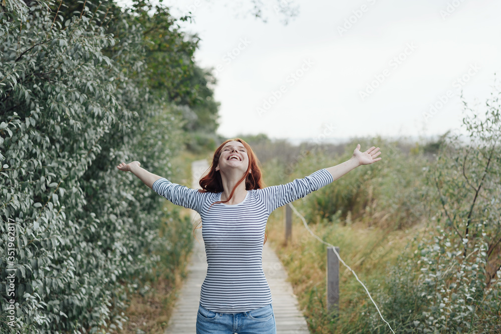 Happy young woman celebrating being in nature